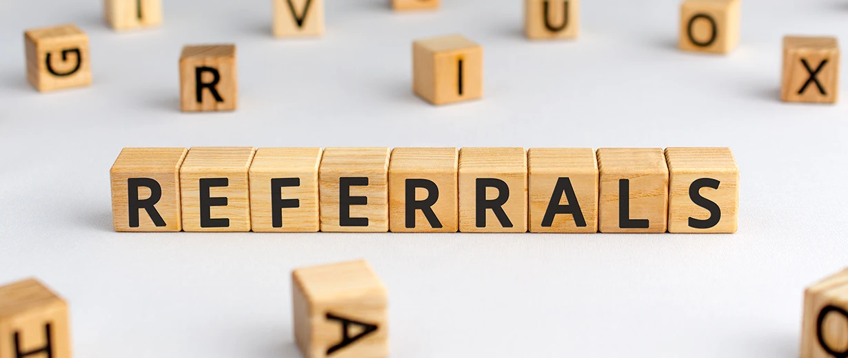 Wooden letter blocks spell out REFERRALS.